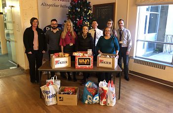 Image of staff behind Christmas tree with food hampers
